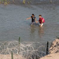 Texas traps pregnant migrants in razor wire, pushes kids back into Rio Grande, state trooper complains